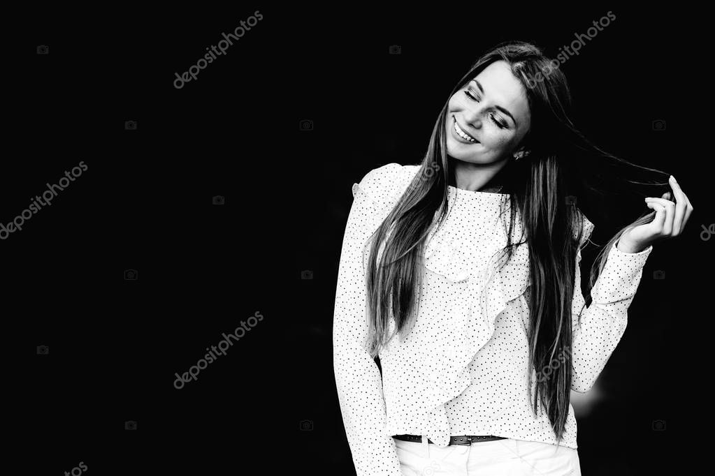 a pretty girl with long hair and stylish clothes walking in the park on black and white photography