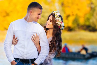 başarılı bir adam onun ellerini ceplerine tutar ve karısı onu yüzünde bir gülümseme ile kucaklar. Arka planda bir tekne göl ve sarı ağaçlar üzerinde kişi vardır