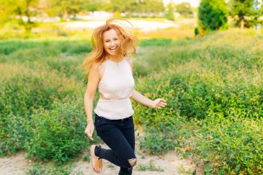 Kız eğleniyor ve yeşil çim arasında bir yolda çalışan