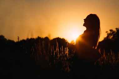 kız kim akşam gökyüzü ve güneş arka plan alanında silüeti