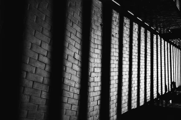 shadows in the form of a column on a brick wall on black and white photography