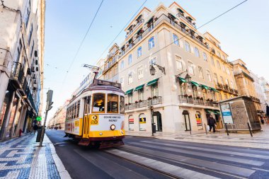 Lisbon, Portekiz - Ocak 2018 güzel sarı tramvay şehrin sokaklarında ilerliyor. cadde ve sokaklar yürüyen turist her iki tarafta muhteşem mimarisi ile binalar