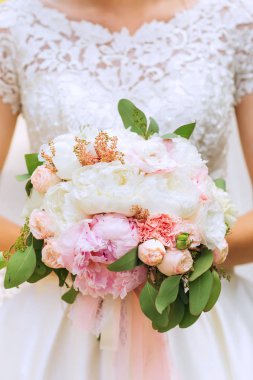 Gelin Gelinlik bir dantel ile tutan bir hassas düğün buket Close-up. gül ve peonies şık düğün buket