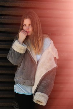 Bir ihale ve şehvetli sarışın mavi kazaklı yüzünü dokunur ve kameraya benziyor.