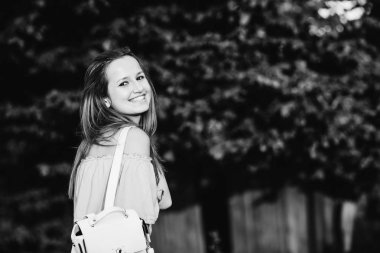 mutlu kız gülümsüyor ve kamera objektifi siyah-beyaz fotoğrafa bakar