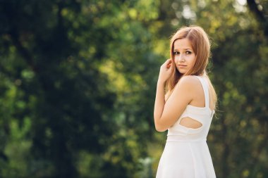 Genç bir kızın saçlarını elini tutar ve indignantly kamera lens görünüyor