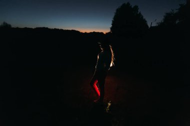 gökyüzü, silhouette orman ve yapay ışık önünde duran şapkalı kız akşam