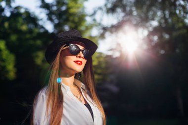 bir genç kızın ağaçları ve güneşin arka plan üzerinde uzun saçlı şık görüntü