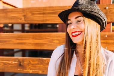 Kız gözleri sevinçle kapalı ve içtenlikle gülümsedi ahşap bir çit arka planı