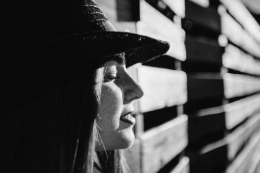 Bir kızın yüzü çilli gözleri kapalı ve siyah ve beyaz fotoğraf ahşap bir çit eğildi yakın çekim profili