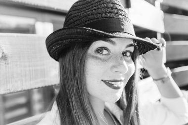 Yüzünde şapkalı kız çil ve o bir siyah beyaz fotoğraf üzerinde kamera lensi görünüyor.