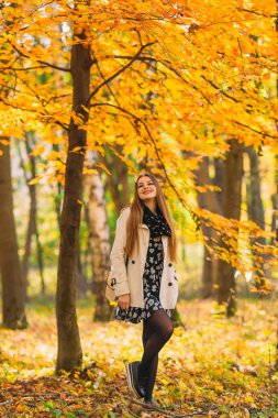 Uzun sağlıklı saçları, güzel güzel genç kız elbise güneşli günde sonbahar Park'ta yürüyordunuz. Yaşam tarzı kavramı. Gençlik ve mutluluk.