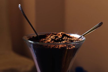 Bir bardak doğal çekilmiş kahve ve iki kaşık bir close-up