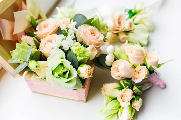 一个美丽的木盒与玫瑰和附近的胸花新郎和伴郎的侧面视图 — 图库照片