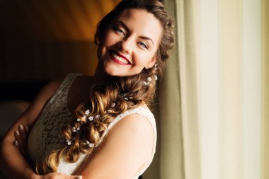 güzel makyaj ve perde yanında duran ve kamera lensi seyir saç modeli ile mutlu gelin