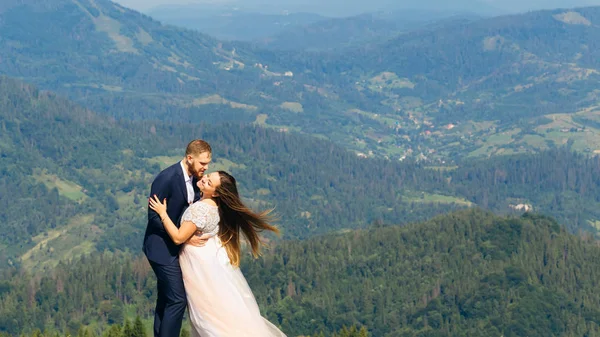 Bonito Abraço Recém Casados Topo Montanha Vento Soprando Cabelo Noiva — Fotografia de Stock