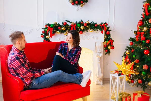 Casal Apaixonado Sentado Sofá Vermelho Sorrindo Para Outro Uma Sala — Fotografia de Stock