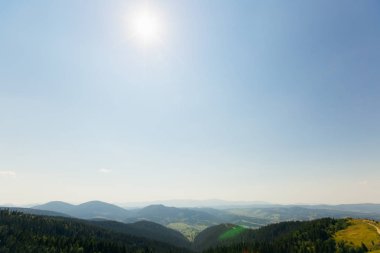 iğne yapraklı ormanlar ve mavi gökyüzü bulutlar olmadan üzerinde güneşin dağların doruklarına kaplıdır