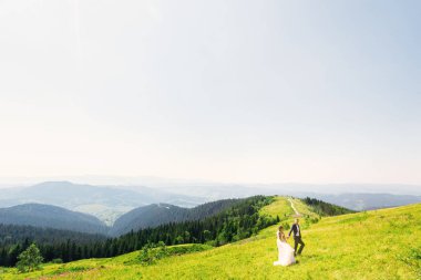 çayır dağ ve kim el ele tutuşup birbirimize bakıyoruz yeni evliler en üstünde yeşil çim ile