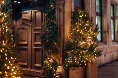 Krakow, Polonya - 18 Ocak 2018 masif ahşap kapı bina ve Noel ağaçları çelenk tencere ile dekore edilmiş