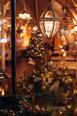 Krakow, Polonya - 18 Ocak 2018 restoranın camından muhteşem iç ve Noel ağacı görebilirsiniz. güzel lambaları ve köknar ağaçları dallarını pencere üzerinde çelenk ile dekore