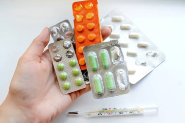 Hangi birçok plakaları elinde üstten görünüm farklı renk ve büyüklükte haplarla. Cam Merkür termometre ile ölçüm sonucu
