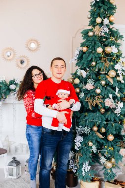 Baba hugs arka yüzü ve anne oğlu Baba arka taraftan bir şömine ve güzel arka plan üzerinde hugs süslenen Noel ağacı