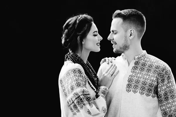 Yeni evliler işlemeli giysiler yüz yüze ayakta ve siyah ve beyaz fotoğraf üzerinde birbirlerine bakmak