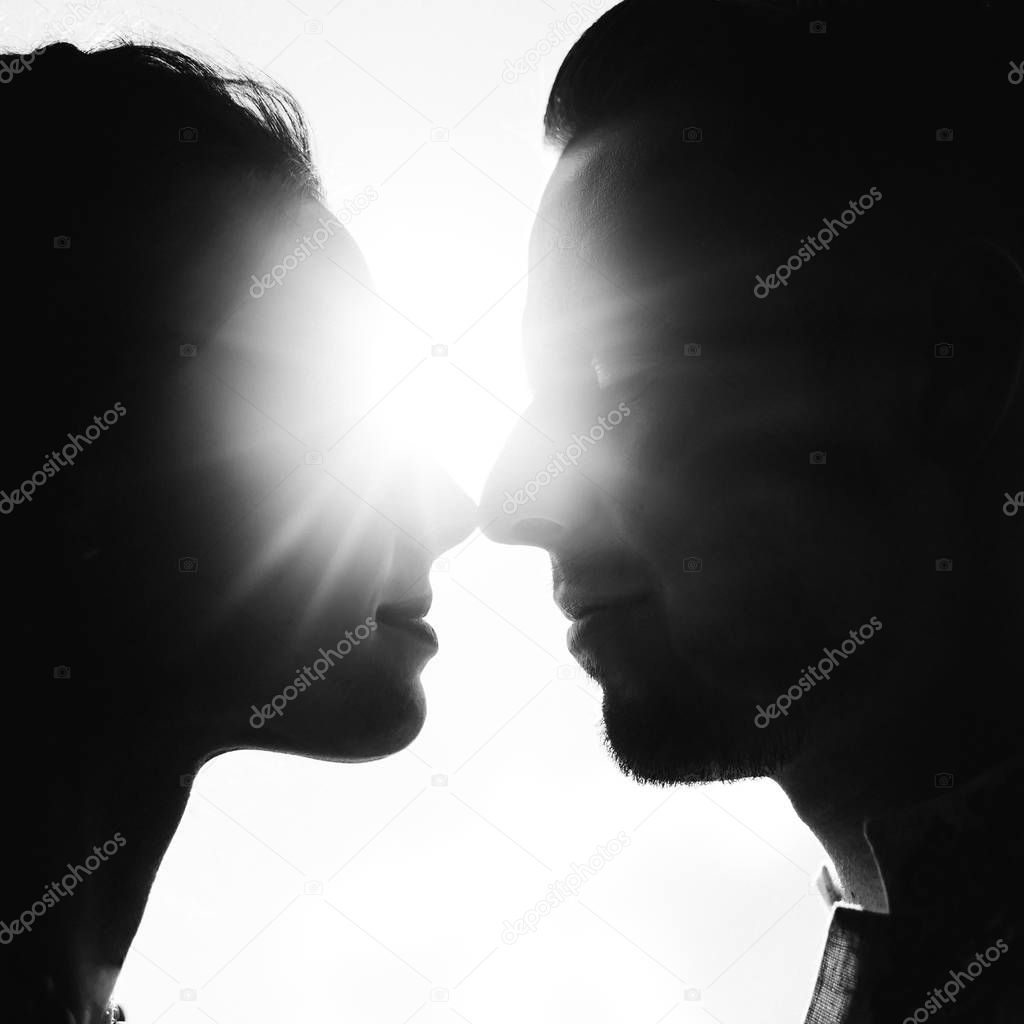 couple kiss and sun rays between them