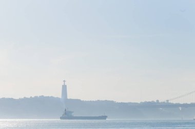 Lizbon Portekiz - 20 Ocak A picturesque river Tagus ile büyük bir gemi. Silhouette ters banka ve köprü ve nehir kıyısında bir anıt