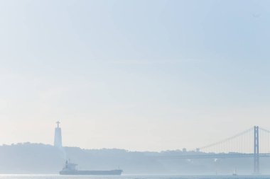 Lizbon Portekiz - 20 Ocak Tagus Nehri üzerinde büyük bir anıt silüeti. bir kargo gemisi ve iki shores bağlayan bir köprü