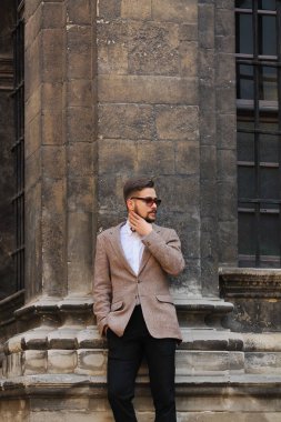 Eski şehir şık elbiseli yakışıklı genç adam. Erkek güzellik, moda.