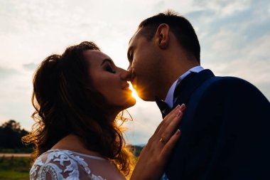 Güneş ışınları yakın çekim aralarında yeni evliler akşam öpücük olduğunu