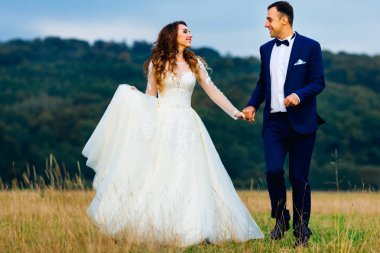 Çift el ele tutuşup birbirlerine bakıyorlar. çimenlerin üzerinde çalıştıkları