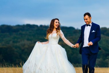 Çift el ele tutuşup birbirlerine bakıyorlar. çimenlerin üzerinde çalıştıkları