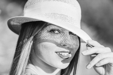 Şapkalı güzel bir kız kamera lens görünüyor ve ileri şapkasını bir siyah beyaz fotoğraf