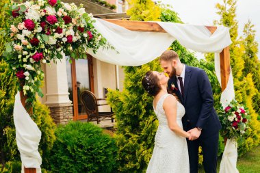 Yeni evliler restoranın arka planda süslemeleri ile güzel bir kemer yakın duran ve öpmek istiyorum