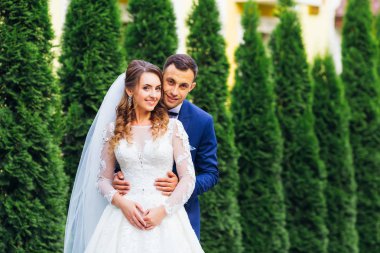 damat gelini arka taraftan kucaklayan ve kamera lensi görünüyorlar