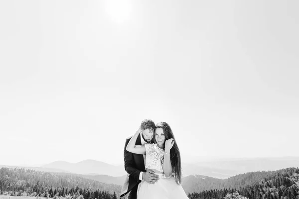 Νύφη Και Γαμπρός Που Αγκαλιάζει Κάθε Άλλο Φόντο Στα Βουνά — Φωτογραφία Αρχείου