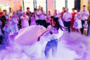 the groom holds the bride in his arms and they whirl in the wedding dance