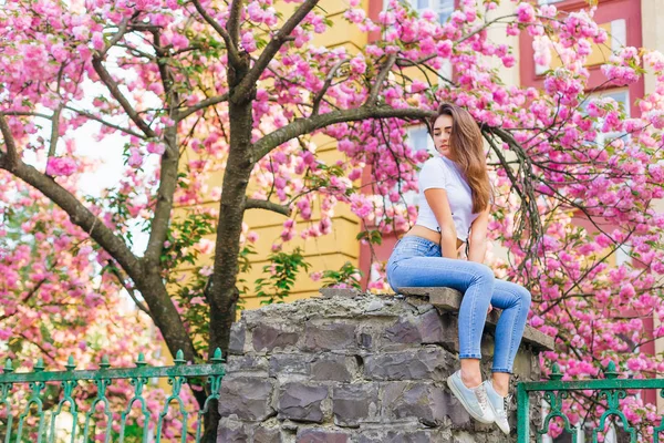 Menina Sedutoramente Senta Pilar Pedra Cerca Sobre Sua Árvore Flores — Fotografia de Stock