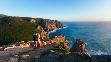 tepeler ve kayalar Bulutsuz gökyüzü ve okyanus kıyısında. bir kaç içinde birbirlerine okyanusun kıyısında kucaklayan aşk