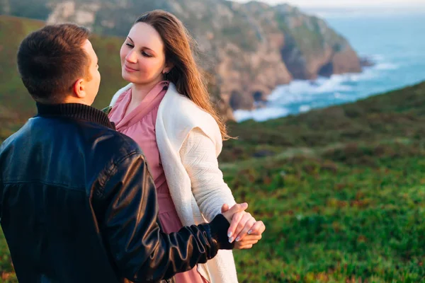 愛に包まれたカップルが手を取り合いお互いを見る 彼らは海の岩だらけの海岸にいる — ストック写真