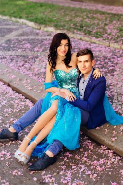 o kız erkek pembe akışı yaprakları arasında diz oturur