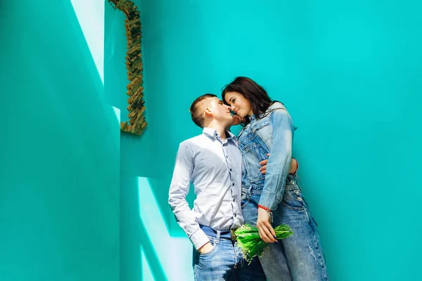 Couple en jeans près du mur bleu — Photo