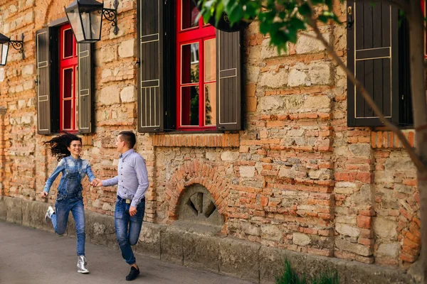 La pareja enamorada diviértete. se agarran de las manos y corren a un lado — Foto de Stock