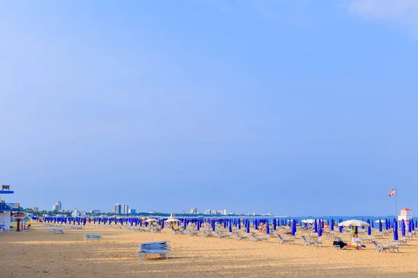 Ліньяно-Сабб'ядоро Італії - 3 липня 2018 великий піщаний пляж з великою кількістю парасольками. Міські будівлі — стокове фото