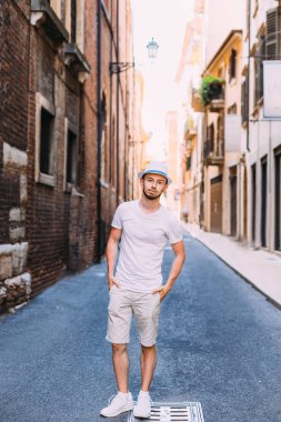 Beyaz giysiler ve hasır şapka şık sakallı adam el ele tutuşsun 