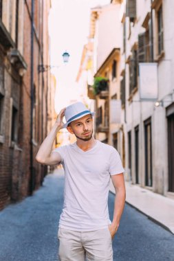 Beyaz giysiler ve hasır şapka sokakta sakallı bir adam 