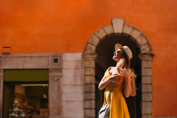 Een meisje in een gele jurk en boater poses op de achtergrond van de — Stockfoto